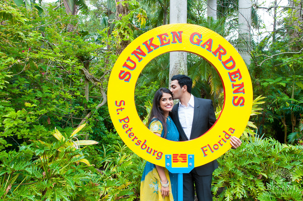 Indian couple posing by the Sunken Gardens, St. Petersburg, Florida sign during their Florida Indian Engagement Photography photo-shoot