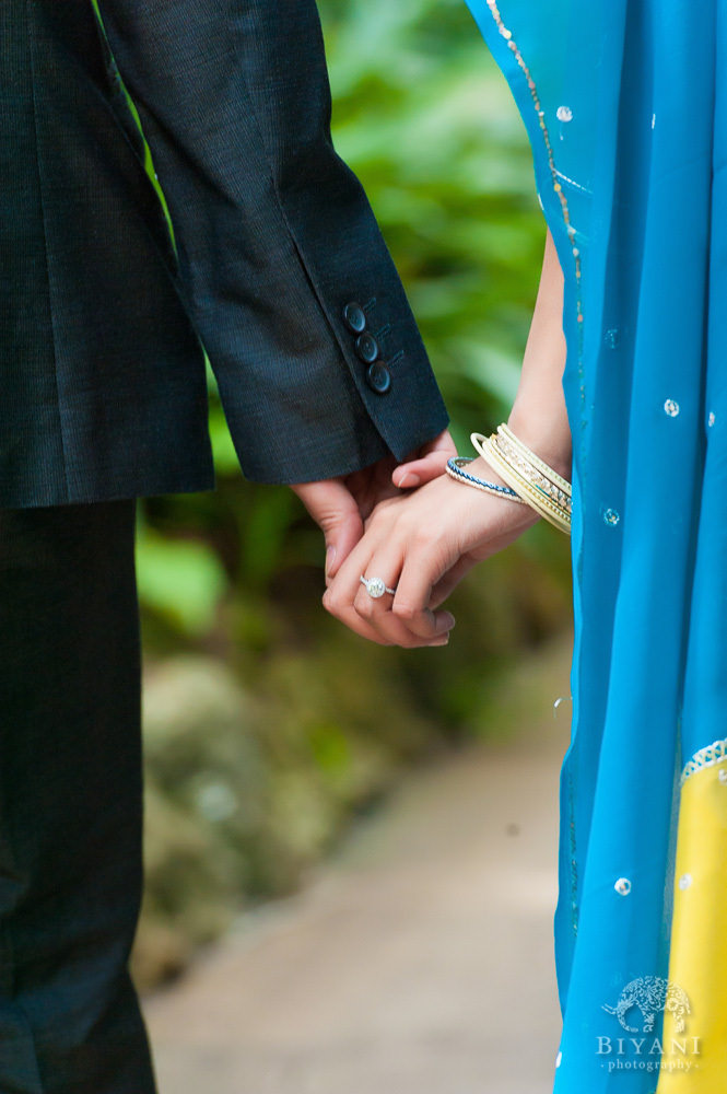 Engaged Indian couple holding hands with fiance's Engagement Ring showing at Sunken Gardens in St. Petersburg Florida