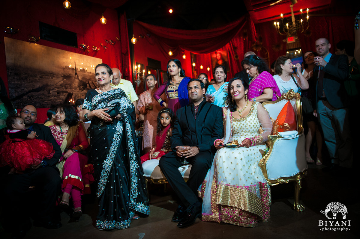 Couple and groom's mom enjoying the Sangeet with a Parisian backdrop