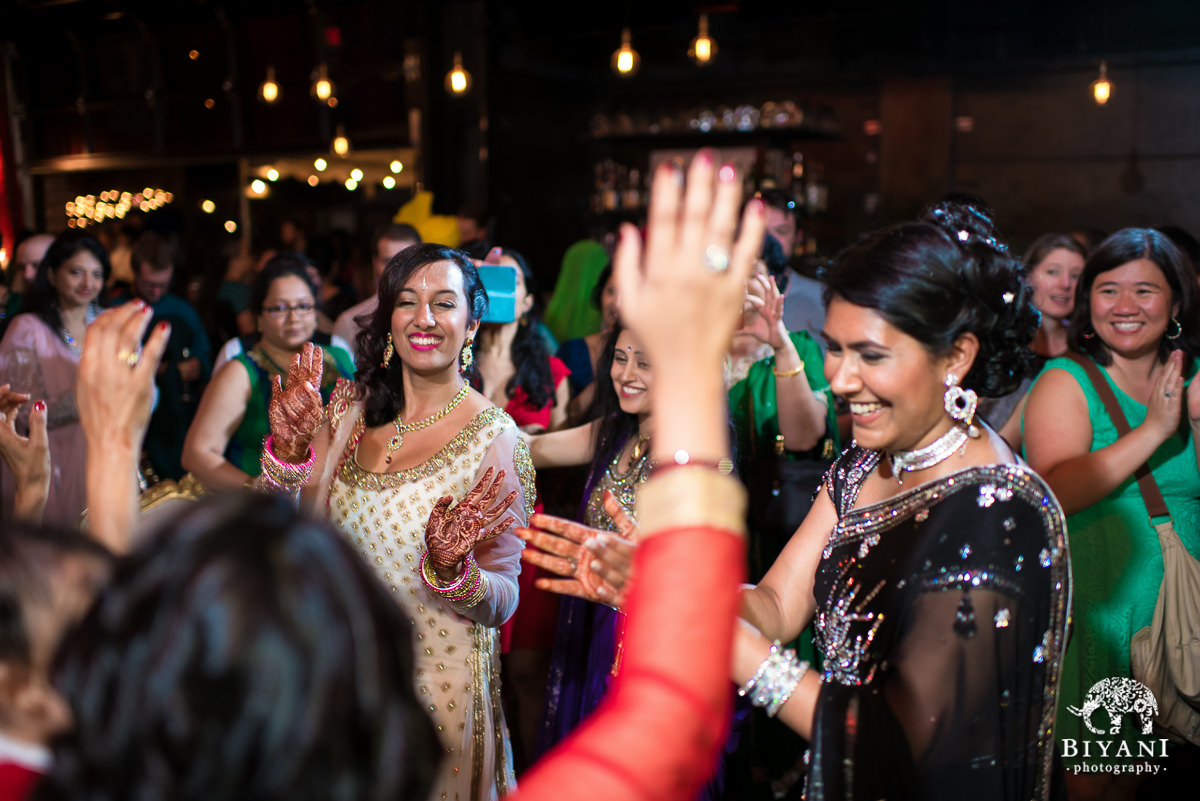 Indian bride dancing with sister-in-law and friends