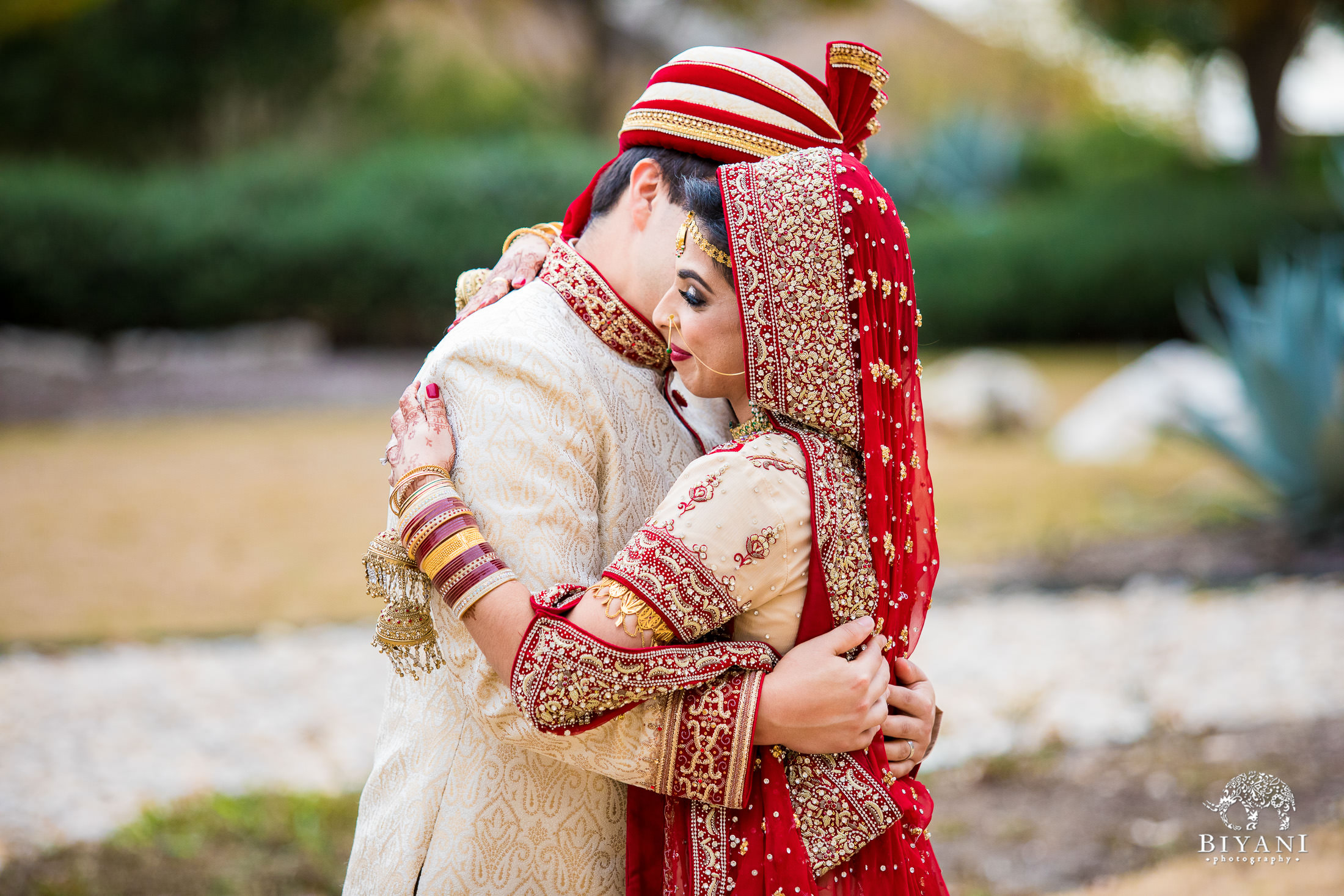 Indian Fusion Bride and Groom hugging after their first look outdoors