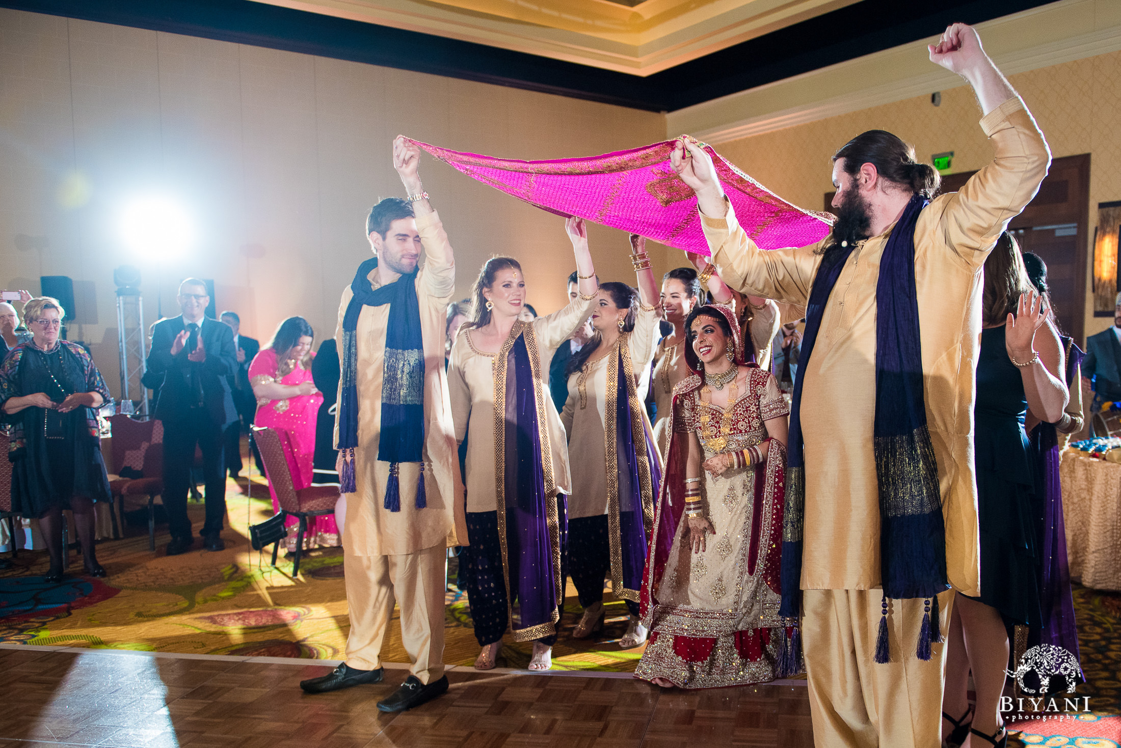 Indian bride entering reception party with groomsmen and bridesmaids 