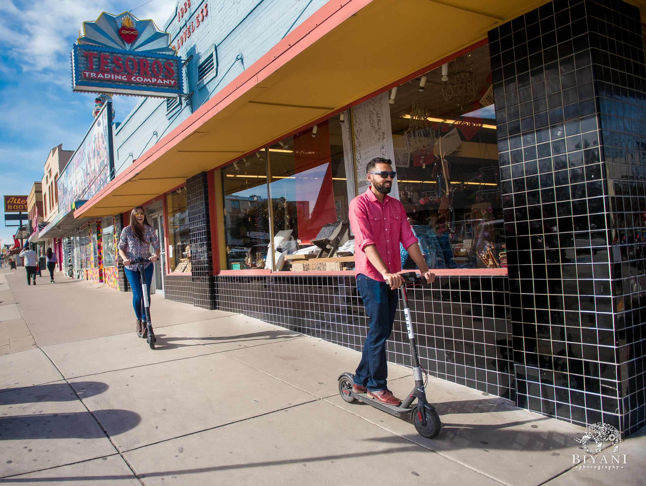 Indian couple riding Bird scooters through the streets of Austin, TX. during their engagement photo shoot