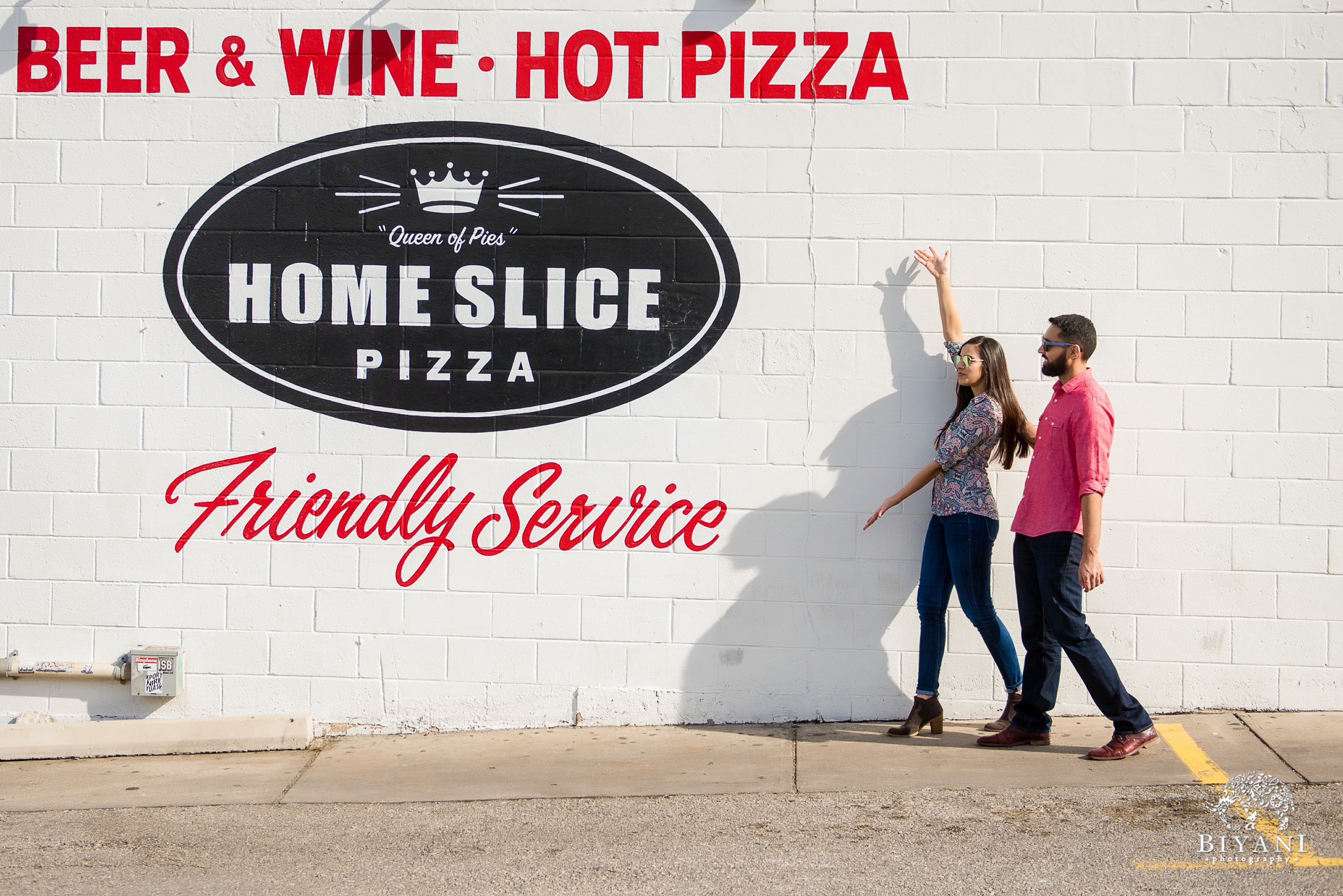 Indian couple in front of Home Slice wall mural in South Congress Austin, Tx. during their engagement photo shoot