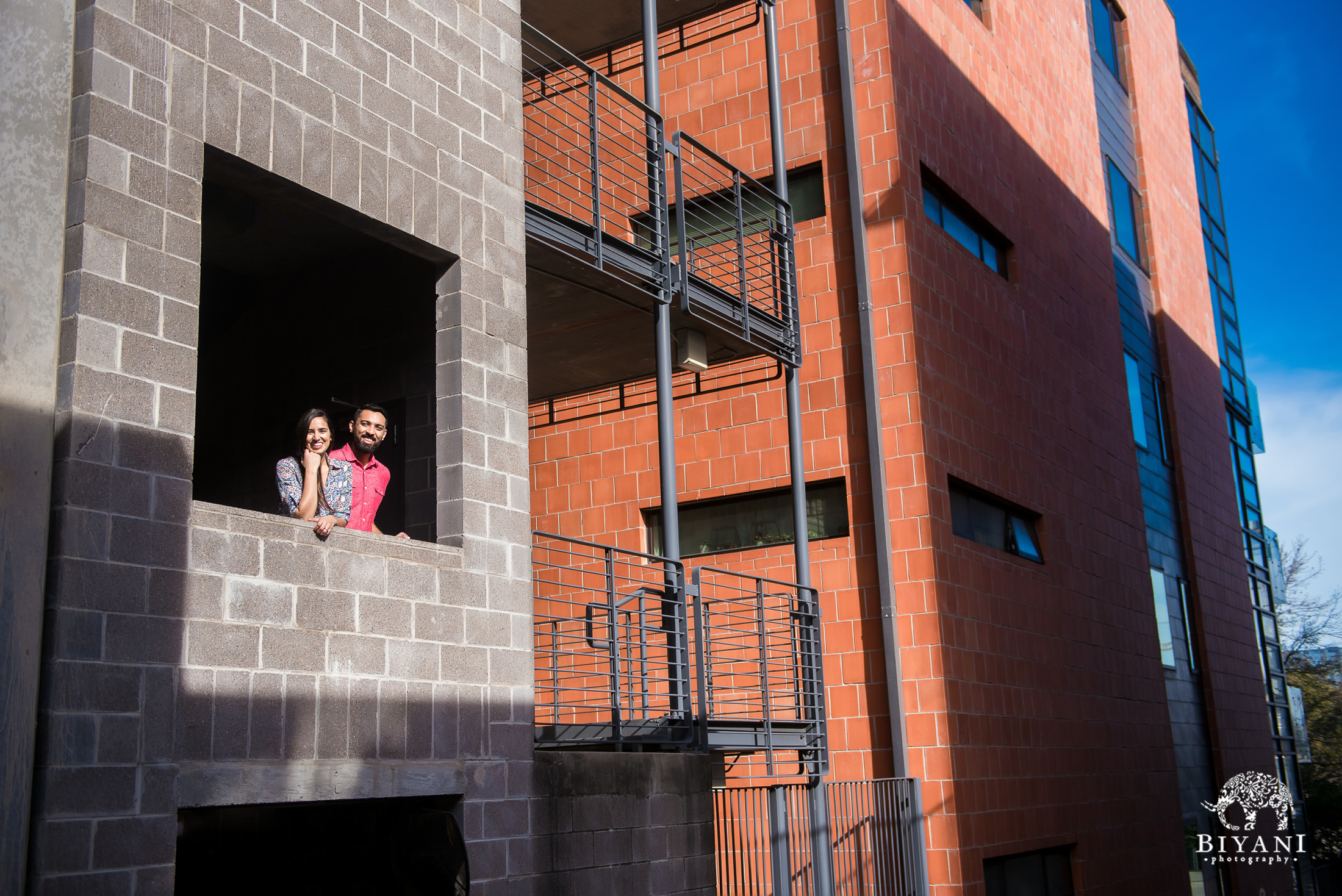 Indian couple from afar in a parking garage posing for their engagement photo shoot in Austin, Tx.