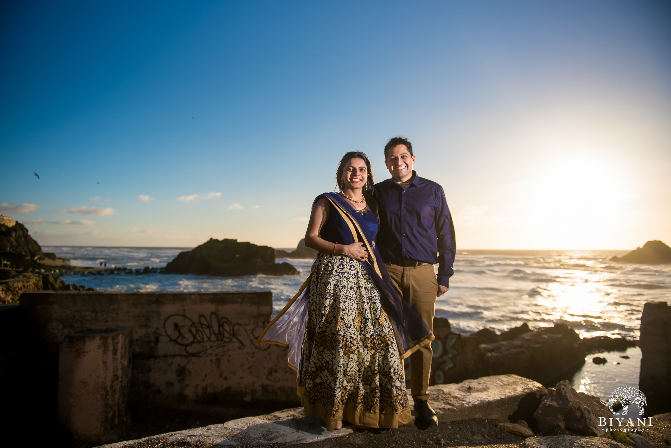 San Francisco Indian Engagement photo shoot with couple posing in front of the ocean front during sunset dressed in traditional Indian dress