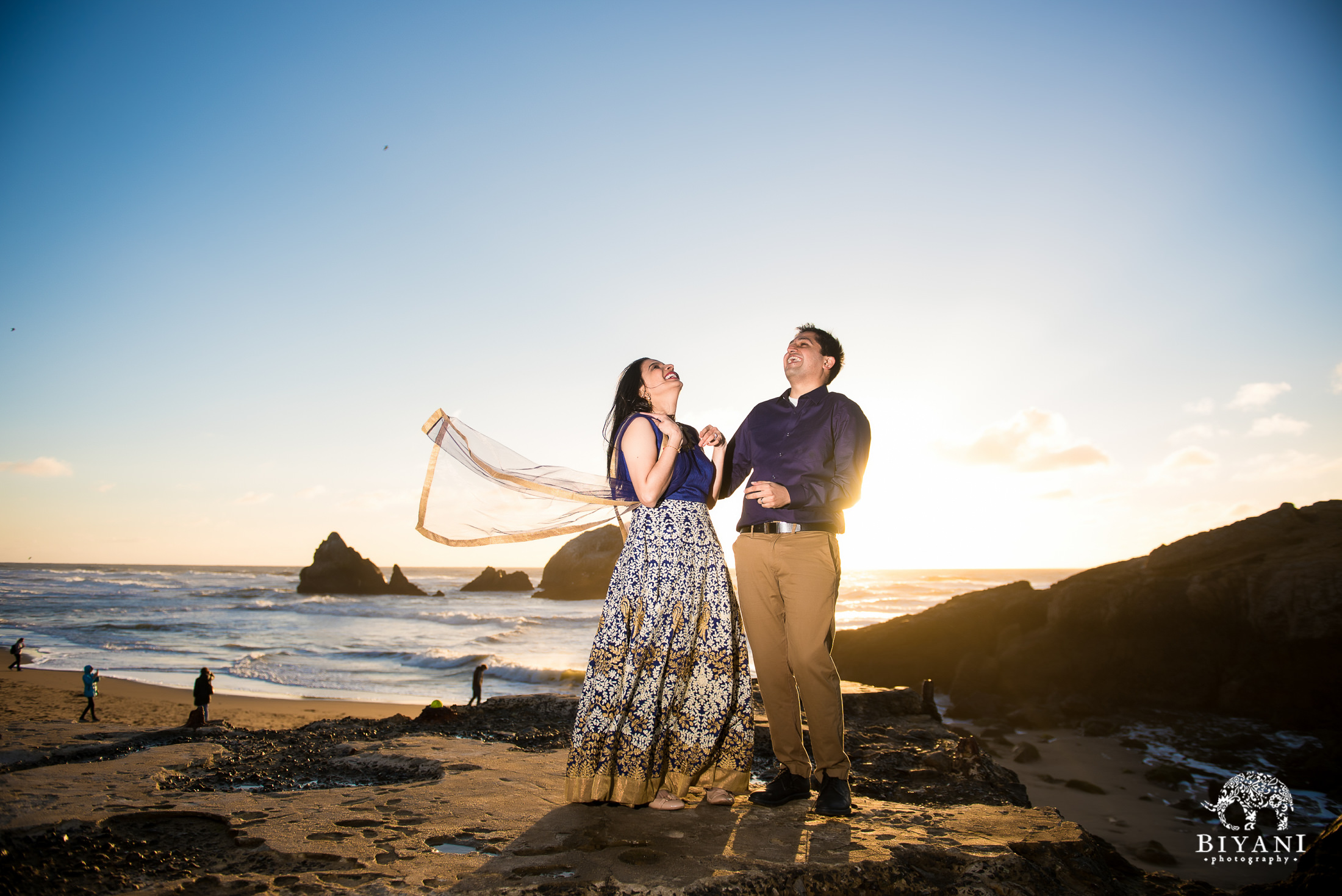 couple standing in front of the beach during engagement photo shoot at sunset in San Francisco 