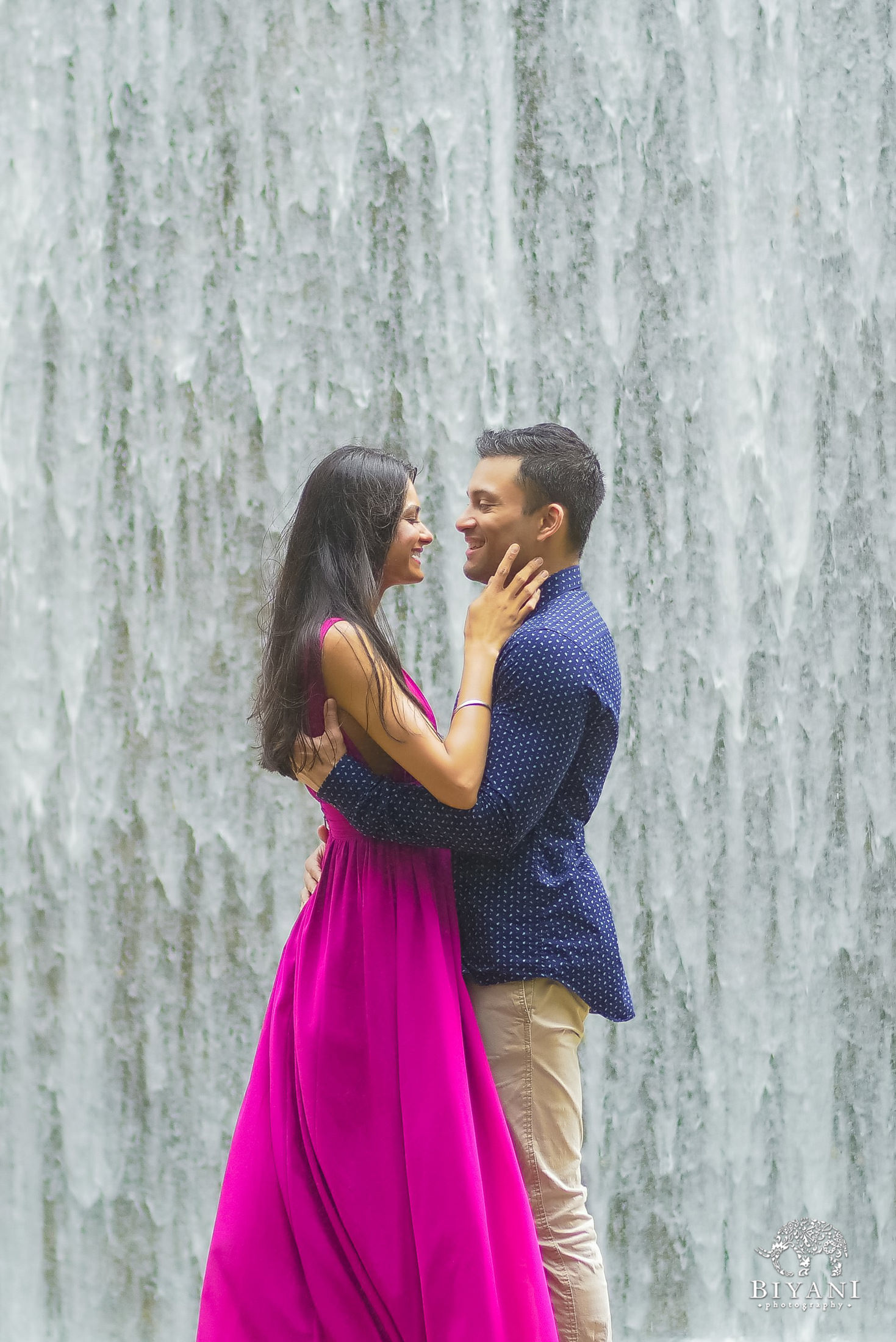 couple almost kissing during engagement shoot in the Houston Galleria Water Wall