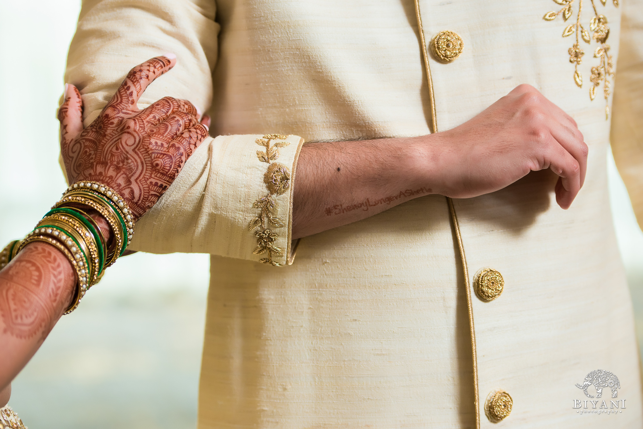 bride resting her hand on groom's arm during couple portraits