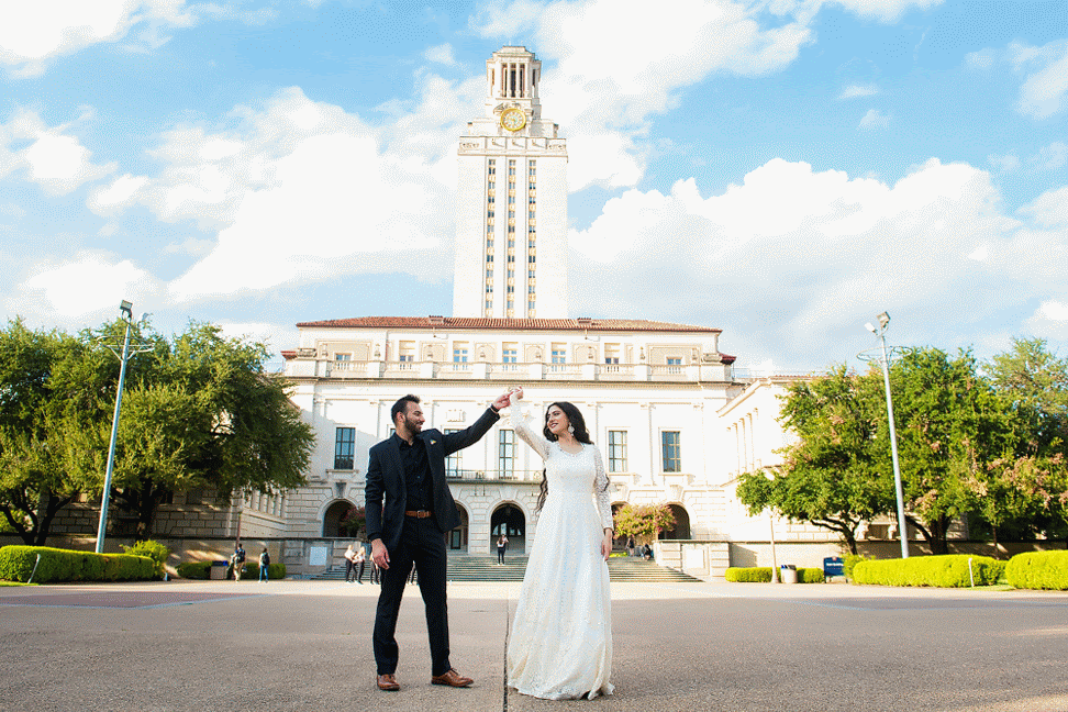 groom twirls bride in front of tower at University of Texas, Austin campus