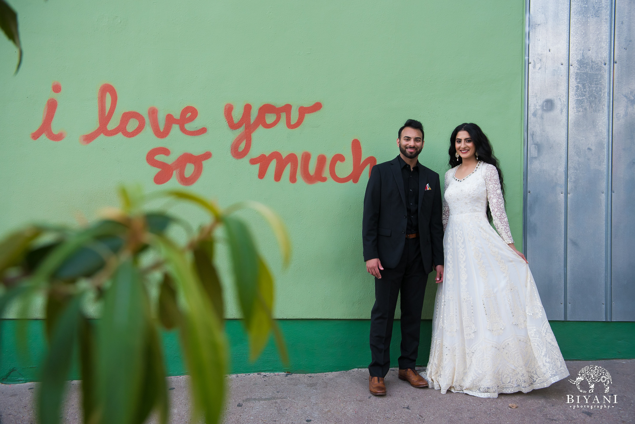 couple poses in front of "I love you" mural in Austin, Texas