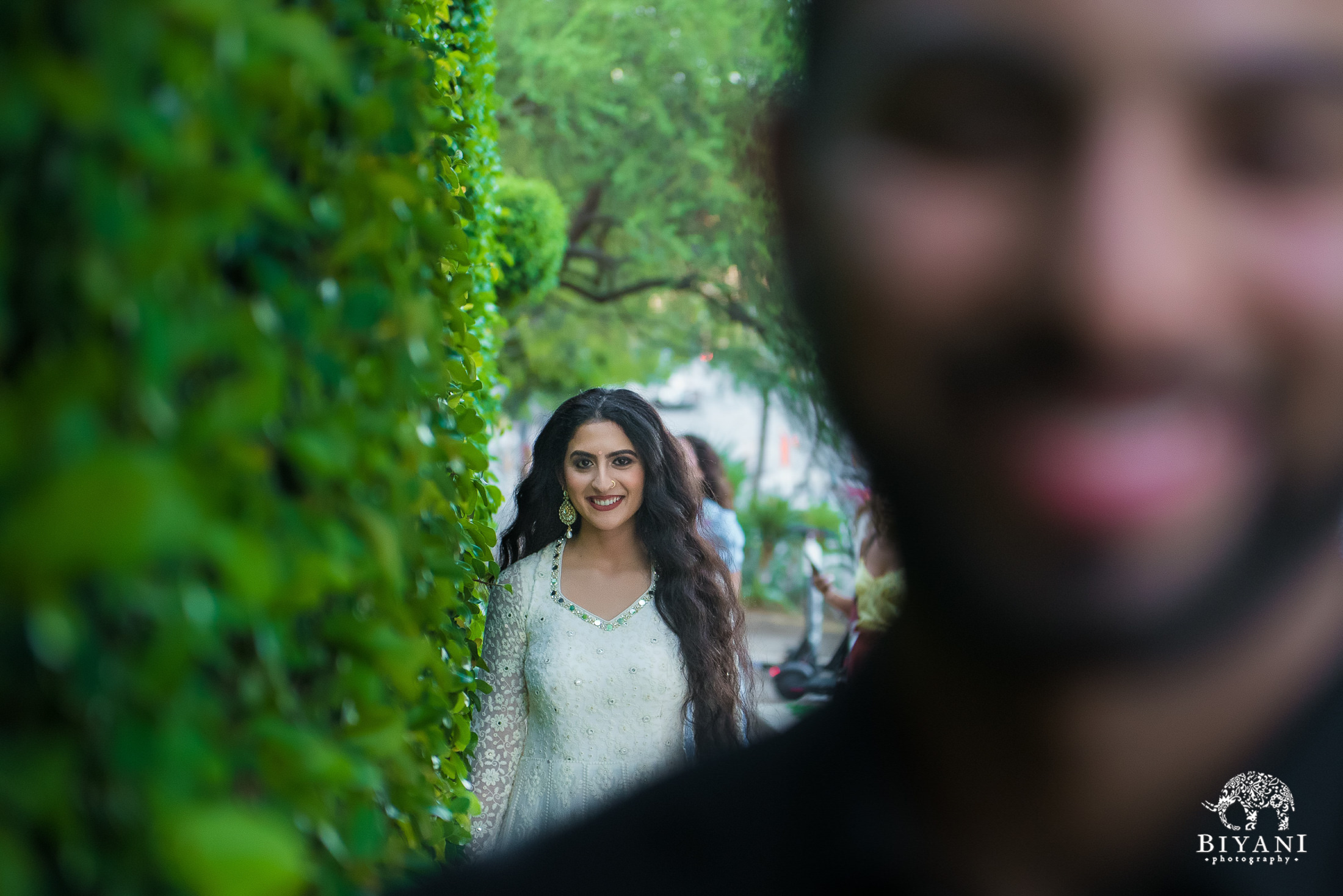 bride in focus sneaking up on groom out of focus from behind