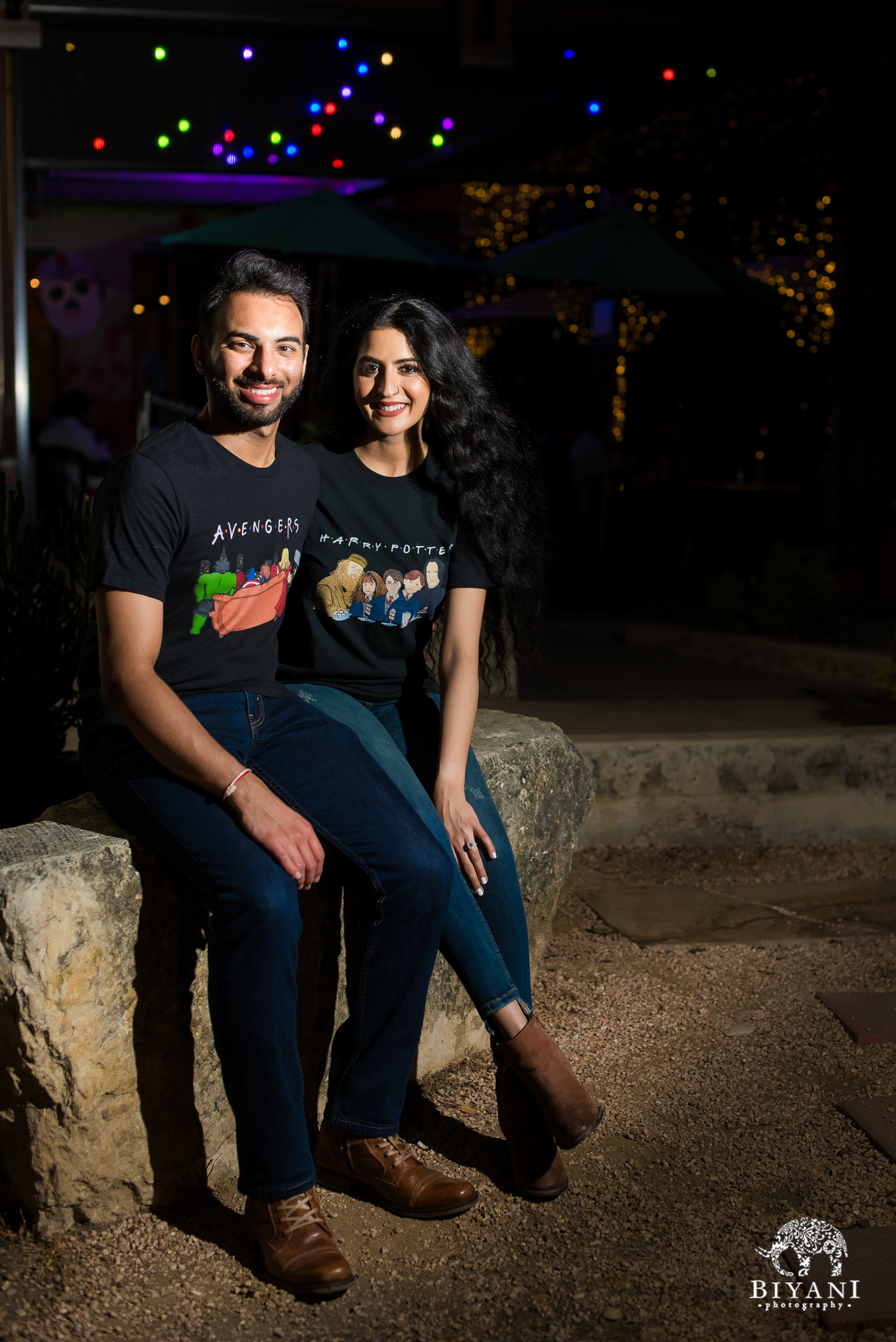 couple sitting on rock in front of coffee shop during the night